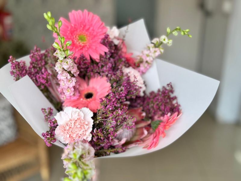 Pink gerbera daisies and carnations bouquet with heather